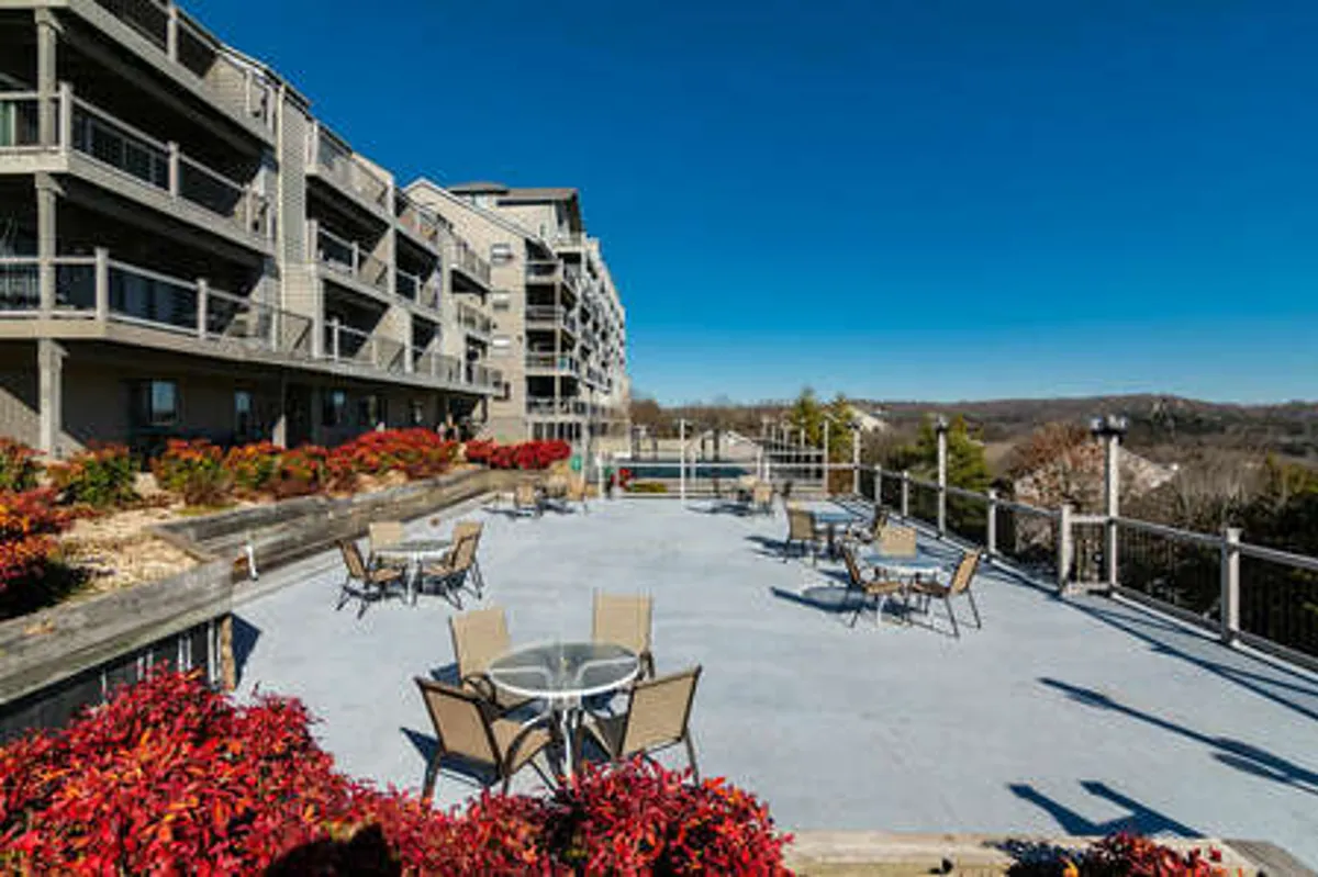 An inviting outdoor seating area surrounded by vibrant landscaping, with the building structure visible in the background. The terrace is positioned to take full advantage of tranquil views, ideal for relaxing outdoors and sharing intimate moments at sunset or sunrise.