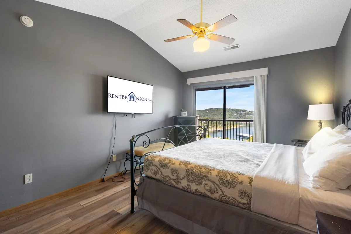 A comfortable bedroom with a plush bed, television, and a window view. The space feels homely and perfect for unwinding after a day of activities, with soft lighting enhancing its cozy ambiance.