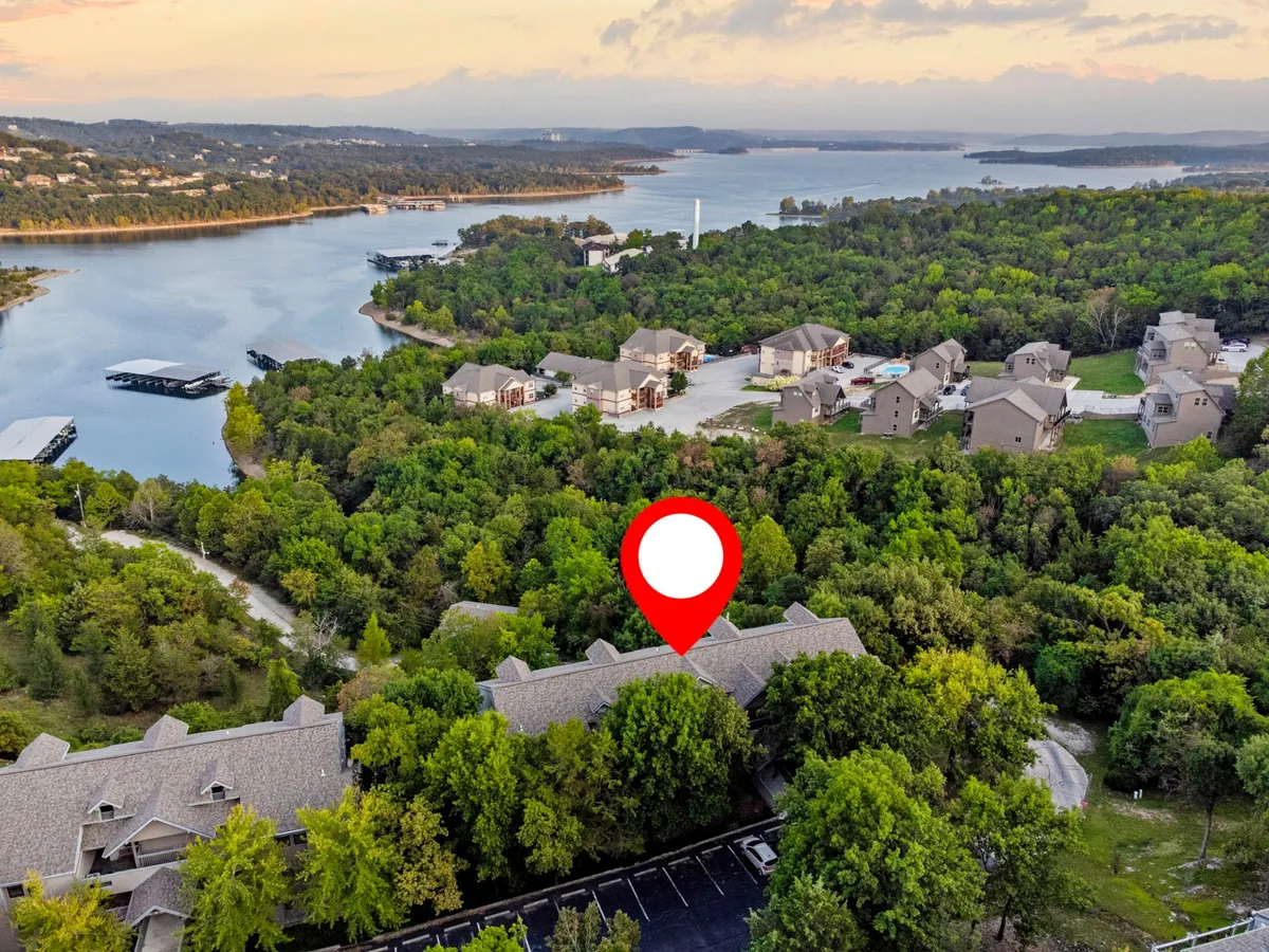 An expansive vantage point of the lake framed by lush greenery with the layout of the neighborhood visible below. The view suggests opportunities for boating, hiking, and wildlife spotting from an elevated position, mirroring the elevated vantage described in the section.