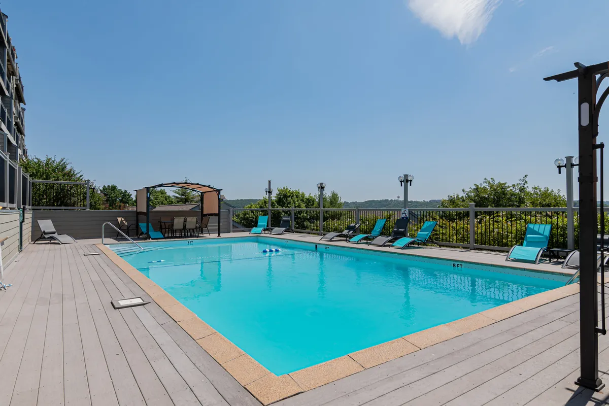 A sparkling outdoor swimming pool is surrounded by comfortable lounge chairs and a charming gazebo, inviting guests to relax, swim, or socialize in a resort-like atmosphere.